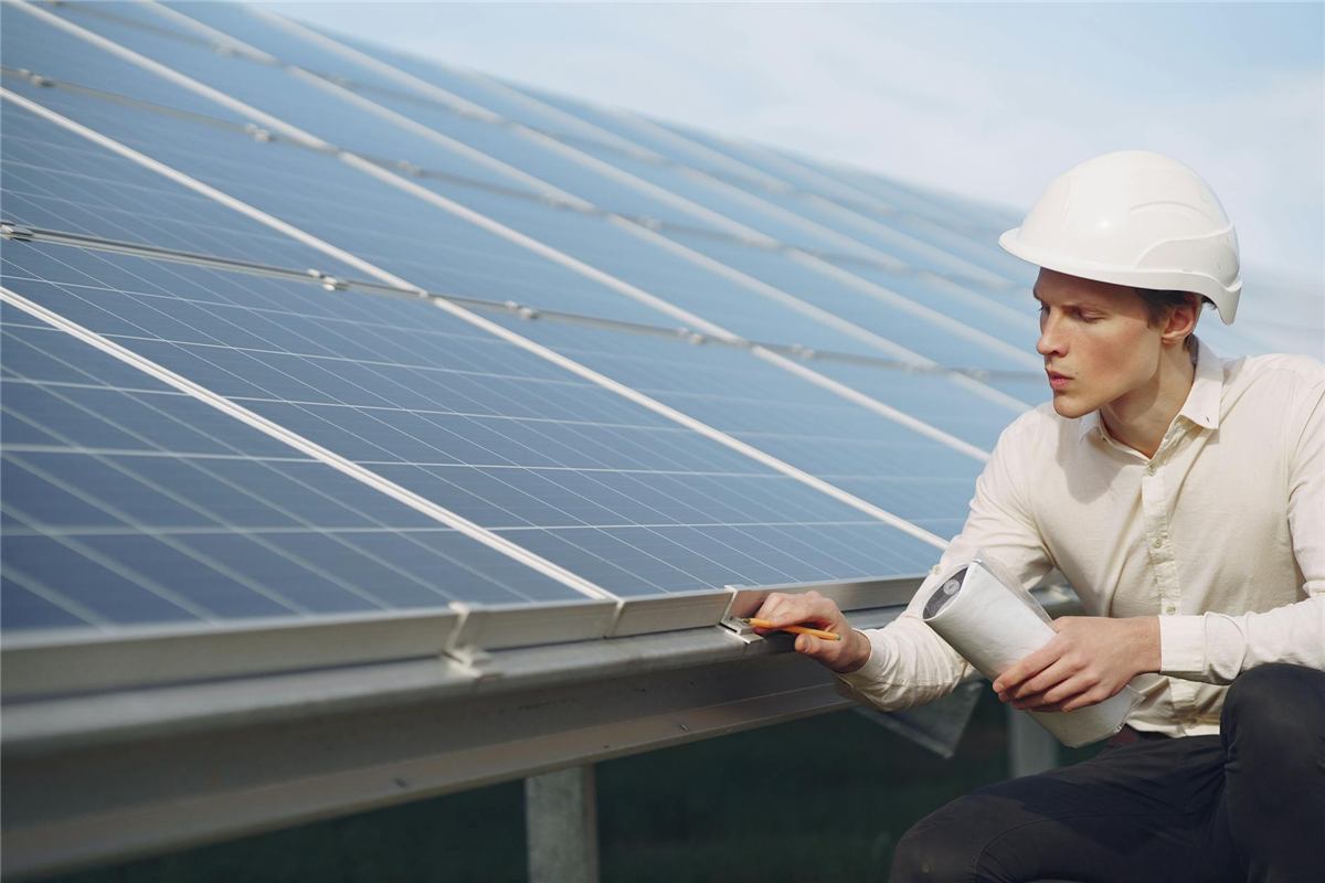 Technik kontroluje solární panely fotovoltaické elektrárny na střeše